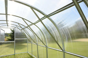 Interior view of galvanized steel greenhouse frame showing arch supports and cross bracing