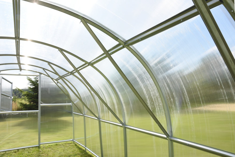 Interior view of galvanized steel greenhouse frame showing arch supports and cross bracing