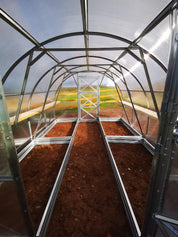 Interior of steel greenhouse with galvanized raised bed frames ready for planting